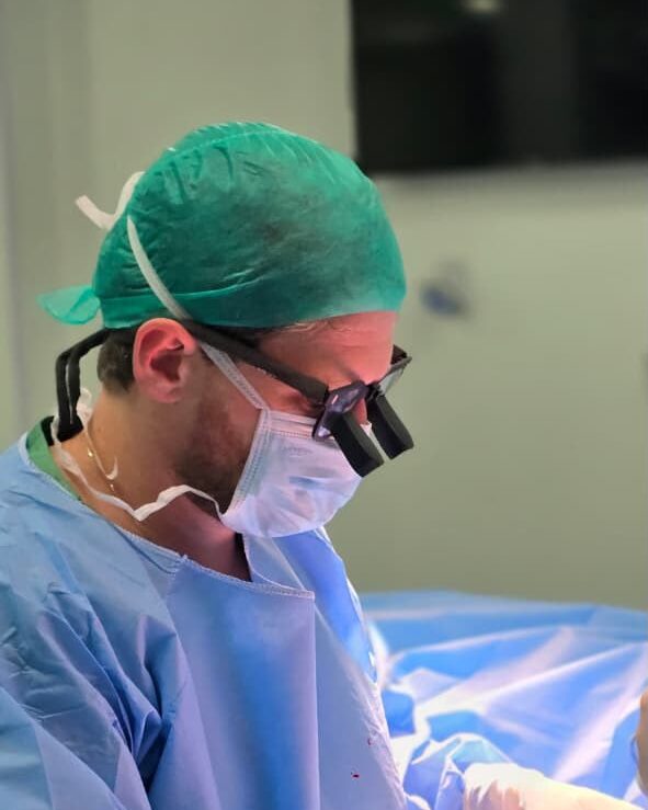 Cirurgião vascular confeccionando fístula arteriovenosa para hemodiálise com lupa cirúrgica no Rio de Janeiro